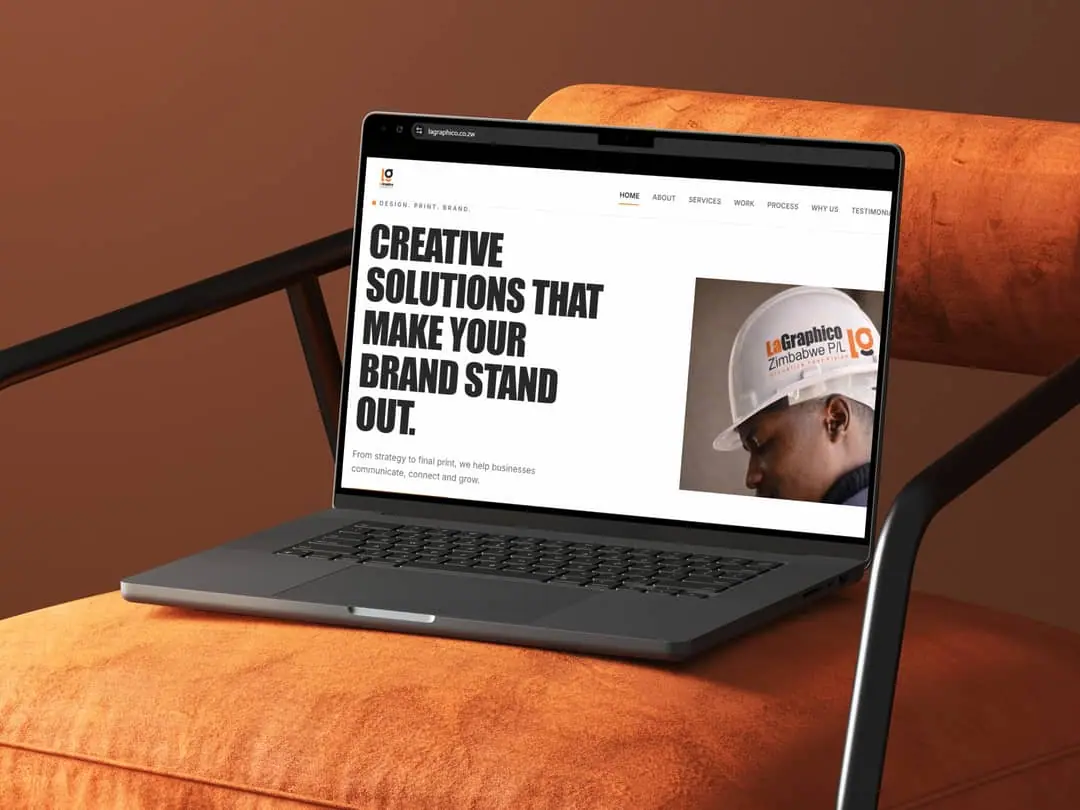 The LaGraphico homepage open on a laptop resting on an orange armchair, showing the headline Creative solutions that make your brand stand out